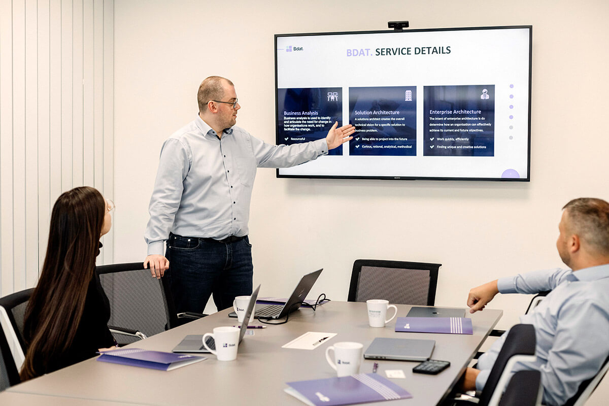Bdat. consultant presenting the service overview slide in a meeting room